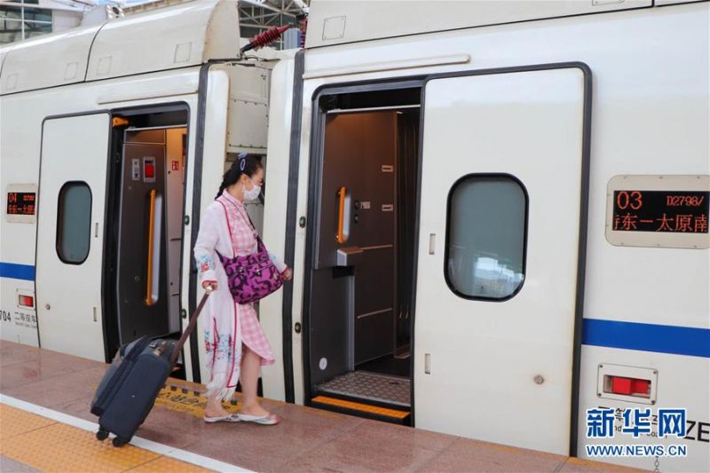 7月1日，在呼和浩特东火车站，旅客登上开往太原南的D2798次“和谐号”动车组列车。新华社记者 朱文哲 摄
