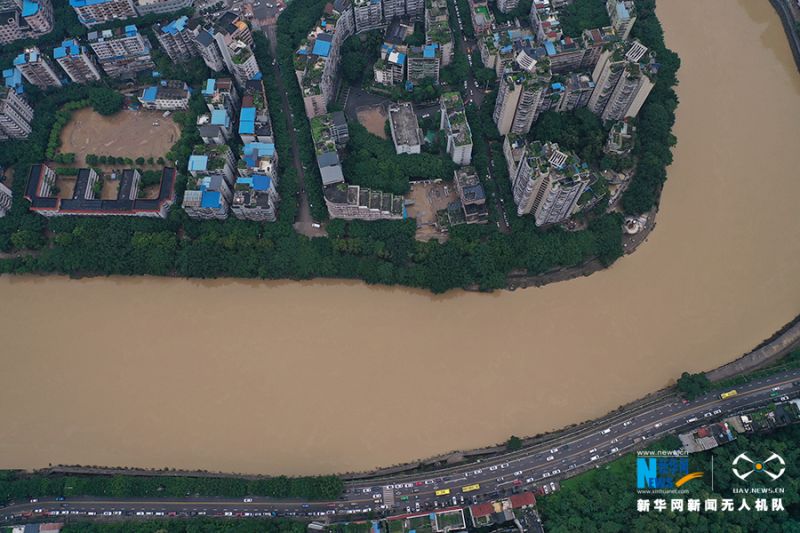 6月23日，洪水减退后，不少地方都堆积了淤泥。从河岸边穿梭的车流可以看出，城市又恢复了生机。新华网 向进 摄