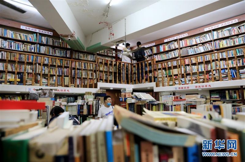 7月13日，读者在复旦旧书店内挑选书籍。 新华社记者 方喆 摄