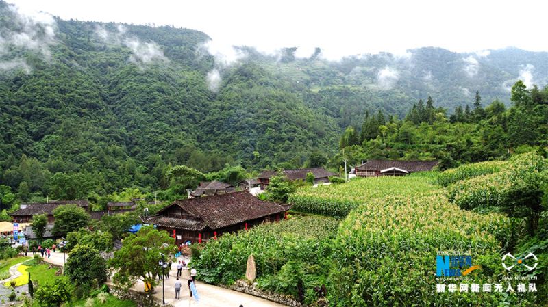 这是无人机航拍视角下的田家寨，在青山白云之下默然而立。新华网 马天龙 摄