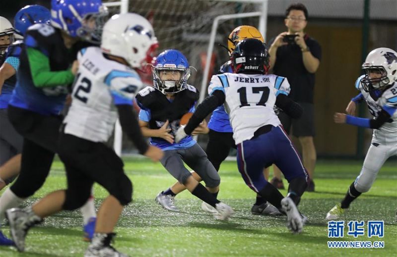 　　7月4日，音速队球员肖涞恩（中）在比赛中进攻。 当日，2020快乐橄榄球联赛首场比赛在上海举行，对阵双方是U11组的音速队和黑豹队，小球员们在球场上奋力拼搏，强健体魄的同时也增强了团队合作的意识。最终音速队以29比6战胜黑豹队。 新华社记者方喆摄