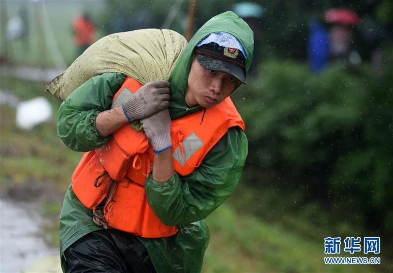 7月16日，在安徽无为长江大堤外护圩三垄圩段，武警安徽总队芜湖支队的战士在搬运沙袋，准备加固子埂。 受连日强降雨影响，安徽省芜湖市鸠江区白茆镇的三垄圩部分圩堤沙土流失，先期加固的子埂出现松动。接到险情后，武警安徽总队芜湖支队立即出动120名官兵展开抢险，加固子埂，保障无为长江大堤安全。 新华社记者 周牧 摄