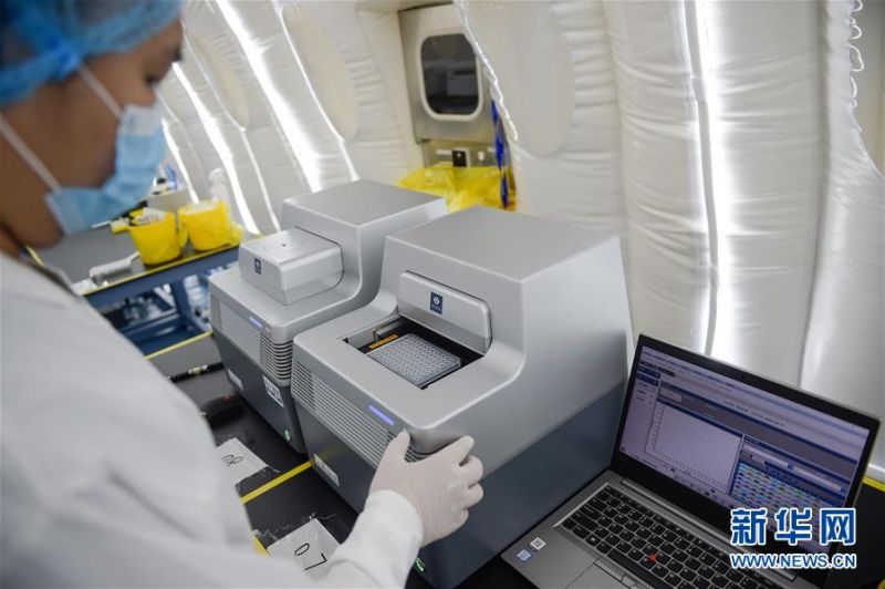 7月1日，在扩增实验室内，实验人员将核酸反应板放入PCR仪中做荧光反应检测。 当日，记者走进北京大兴区体育中心，探访坐落于此的北京首座气膜版“火眼”核酸检测实验室。目前，实验室有16个气膜舱，已累计完成70余万份核酸检测。 新华社记者 彭子洋 摄