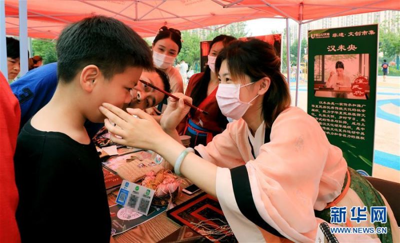 　　6月25日，在上海宝山区U天地商场举行的端午集市上，工作人员为小朋友点朱砂。 当日是端午节，人们外出游玩，乐享假期。 新华社记者 方喆 摄