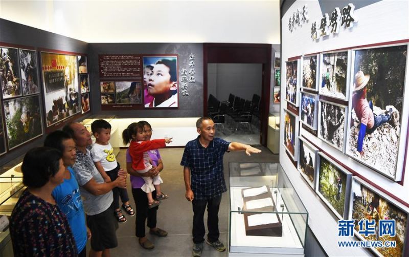 7月3日，下庄村党支部书记毛相林（右一）在下庄精神陈列馆内讲述当年修路的故事。 新华社记者 王全超 摄