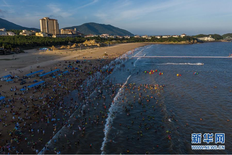　　8月2日傍晚，游客在朱家尖南沙景区的沙滩嬉戏游玩（无人机照片）。　　近期，地处东海之滨的浙江省舟山市朱家尖景区迎来旅游旺季，游客们纷纷前来感受碧海金沙的夏日风情。从7月份开始，朱家尖南沙景区全面升级沙滩夜游项目，开设了夜泳、夜景沙雕灯光秀、音乐驿站、露天电影、沙雕酒吧等服务，同时健全健康码验码进景区、免费提供救生衣、设立夜泳灯光等安全措施，有效延长了景区开放时间，“沙滩夜经济”成为推动当地旅游业发展的特色品牌之一。　　新华社记者 徐昱 摄