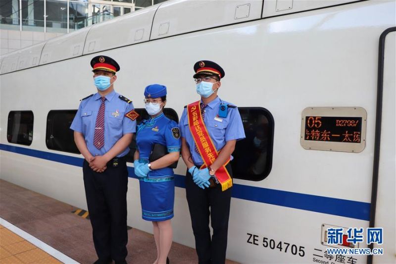 7月1日，在呼和浩特东火车站，铁路工作人员在D2798次“和谐号”动车组列车旁合影留念。