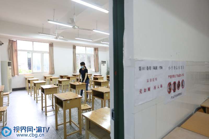 特殊时期，重庆市均各考点设置备用（隔离）考场。图为重庆第十八中学考点备用（隔离）考场监考老师最后检查调整座位间距。