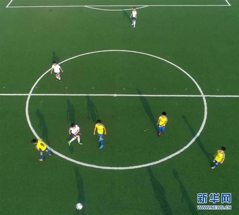 7月16日，青岛通济实验学校的小球员在足球场上进行比赛（无人机照片）。 暑假期间，位于山东青岛即墨区的青岛通济实验学校举办暑期足球训练营，小学生在绿茵场上学习足球基础技能，享受快乐暑假。 新华社发（梁孝鹏 摄）