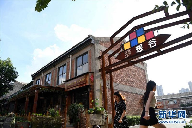 8月4日，人们走在合肥长江180艺术街区。 合肥市瑶海区长江180艺术街区所在地原是一片工业厂房，为有效利用老工业厂房，保留工业文化特色，当地在旧厂房内注入现代元素，将其打造成为集创意办公、文创展示、公共阅读、体育健身等功能为一体的文创园区。 新华社发（解琛 摄）