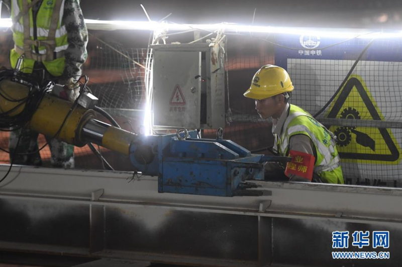 6月24日，中铁四局的施工人员在天桥进行顶推作业时观察液压爬行器作业情况。新华社记者 黄宗治 摄