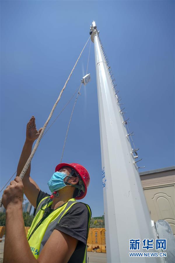 在新疆乌鲁木齐奥林匹克体育中心，施工人员在架设5G基站（7月3日摄）。新华社记者 赵戈 摄