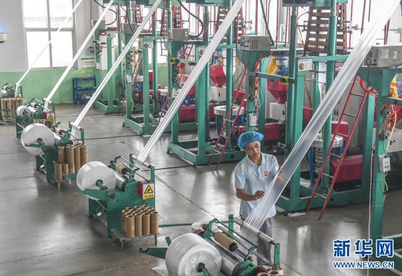 6月26日，在河北省故城县一家食品包装企业，工人在操作吹膜机制作环保食品包装袋。 近年来，河北省故城县积极引导传统产业向高质、智能、环保转型升级，着力打造环保食品包装产业基地。目前，全县已引进包装企业120余家。 新华社记者李晓果摄