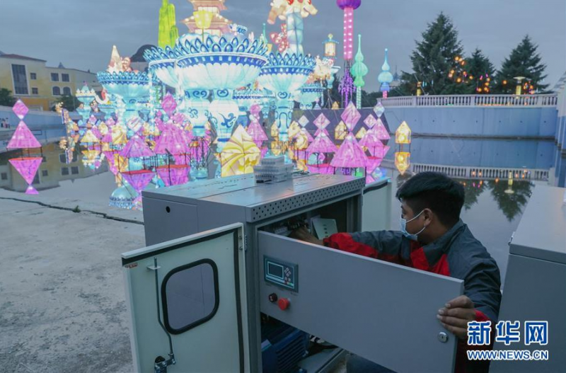 6月26日，江成财为长春市长影世纪城内的大型彩灯组调试电压。新华社发（颜麟蕴摄）