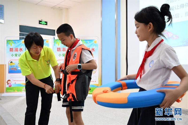 7月10日，在广西柳州市柳北区石碑坪镇中心校，小学生在游泳教练的指导下学习救援技能。 近日，各地学校开展“暑假安全课”主题活动，加强学生们的安全意识。 新华社发（黎寒池 摄）