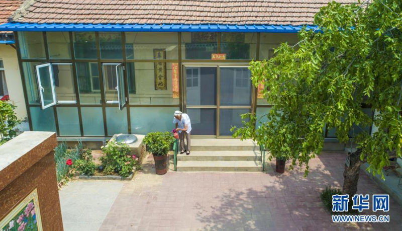 6月27日，河北省故城县郑口镇后响沟村村民在院子里给绿植浇水（无人机照片）。新华社记者 李晓果 摄