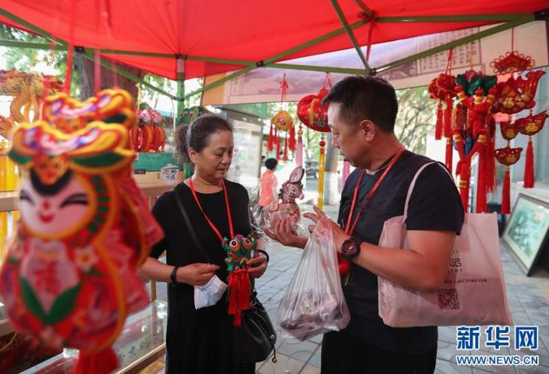 6月23日，市民在在兰州市城关区一处庆阳香包摊位前挑选香包。 端午节将至，甘肃省兰州市城关区街边的庆阳香包摊位吸引许多市民驻足选购。 庆阳香包是甘肃庆阳端午节特色民俗物品，外部是传统刺绣，香料由中草药配置而成，寓意防病驱邪、祈祥纳福。 新华社发（马希平 摄）