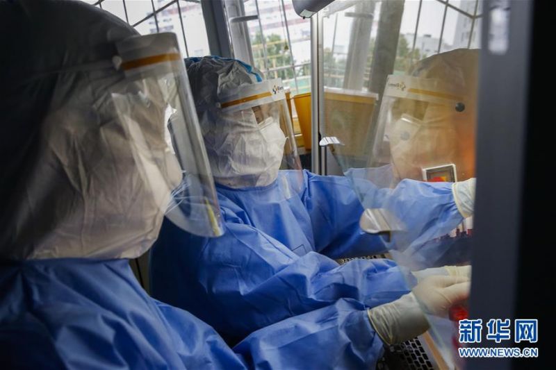 7月3日，中日友好医院检验科新冠核酸检测实验室的检验人员闫克芹（右）和张鑫在实验室内处理刚刚送到的样本。新华社记者 张玉薇 摄