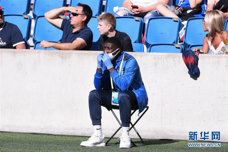 7月12日，一名佩戴口罩和手套的工作人员在场边观赛。 当日，法国勒阿弗尔举行了自三月份以来首场有现场观众的足球比赛，由法甲巴黎圣日耳曼队客场挑战法乙勒阿弗尔队。最终，巴黎圣日耳曼队在这场友谊赛中以9比0获胜。 法国政府6月20日宣布，随着新冠肺炎疫情逐渐好转，对国内大型集会的限制也将逐步放松，集体类体育赛事从7月11日起可以重新回归，各体育场馆最多可以允许5000名观众入场观看比赛。 新华社发（杰克·陈摄）