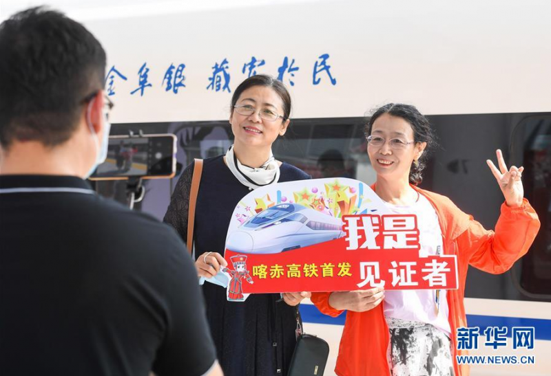 6月30日，乘客在赤峰站与G8382次“和谐号”动车组列车合影留念。新华社记者 彭源 摄