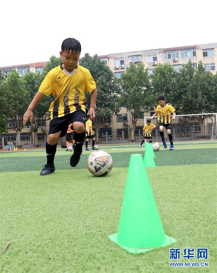 7月27日，在石家庄市柏林南路小学，学生们在进行足球盘带训练。 新华社发（梁子栋 摄）