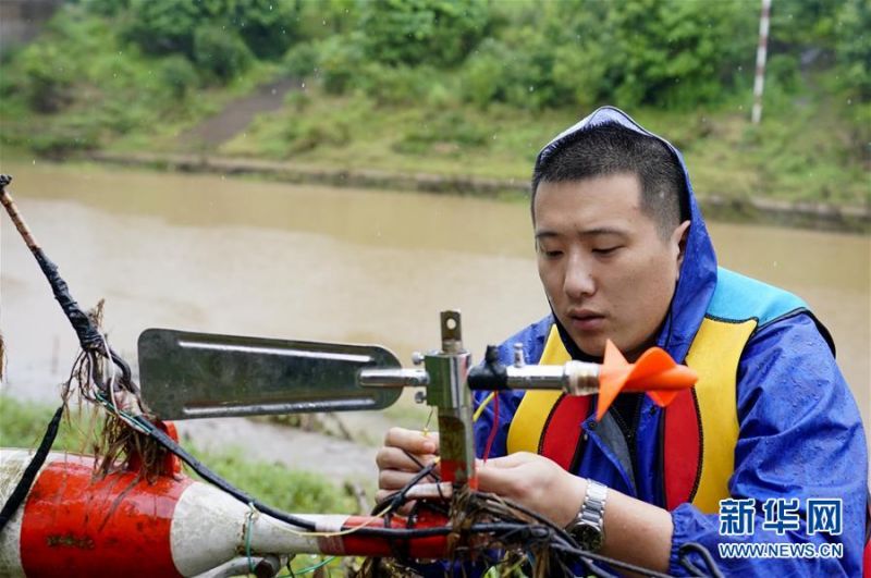 7月1日，在永川区临江河来苏水文站，站长钟睿在安装调试流速仪。新华社记者 刘潺 摄
