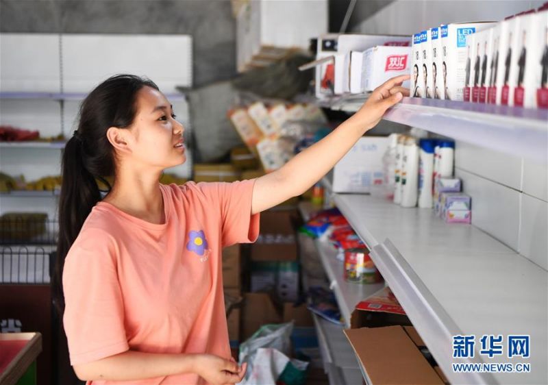 7月3日，18岁的下庄村村民王守名在中国供销合作社开设在下庄村的综合服务社里选购商品。新华社记者 王全超 摄