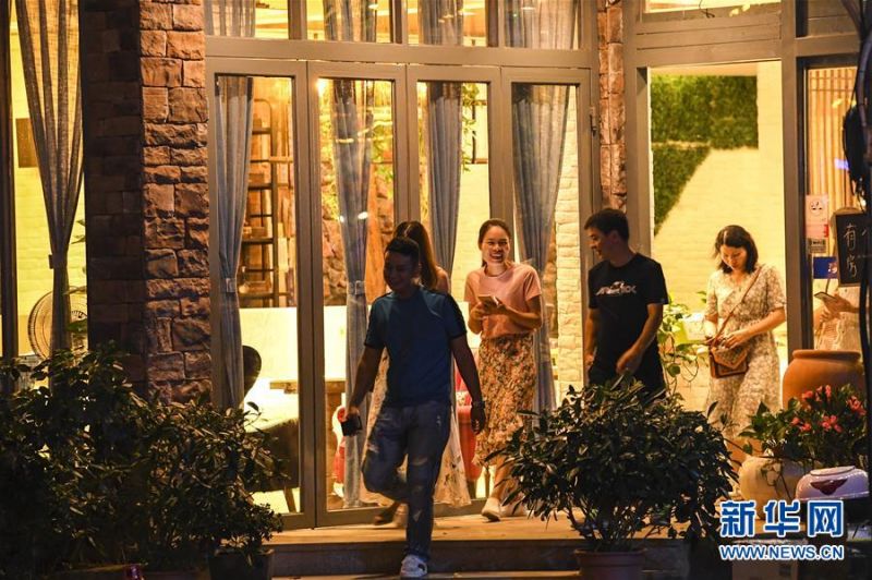 7月4日，几名游客从广西阳朔县西街景区一家民宿酒店走出。新华社记者 曹祎铭 摄