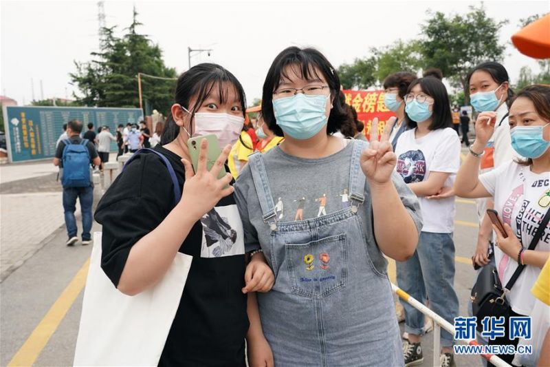7月10日，张晶（左）在考完最后一门选考科目后与同学在学校门口合影。新华社记者 鞠焕宗 摄