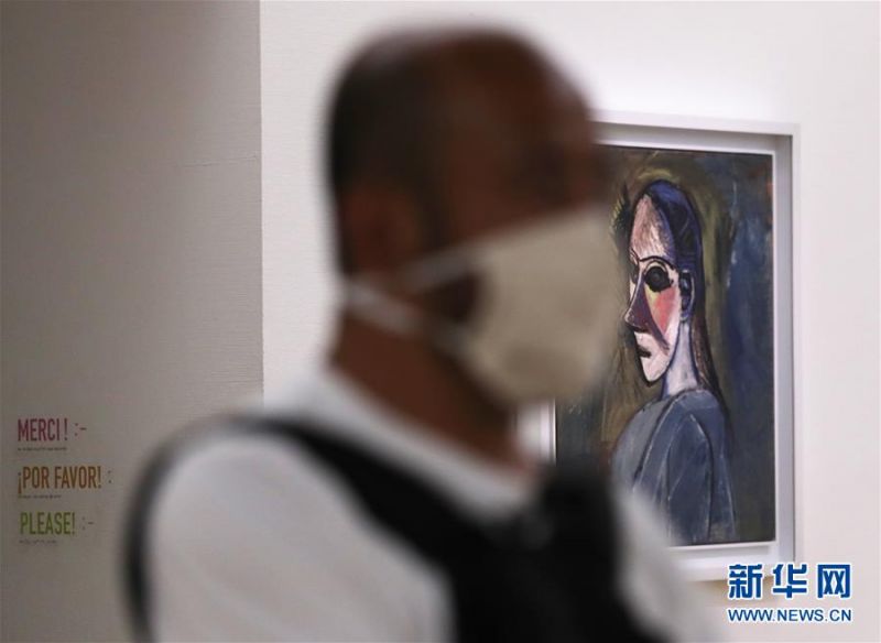 7月1日，一名戴口罩的参观者在法国巴黎蓬皮杜艺术中心走过毕加索的画作。 因新冠疫情关闭的法国巴黎蓬皮杜艺术中心于7月1日重新开门迎客。目前，中心只开放6层的临时展区和4、5层的现代艺术常设展区。参观者需提前网上预约参观时段，11岁以上参观者须佩戴口罩，参观过程中保持安全距离。 新华社记者 高静 摄