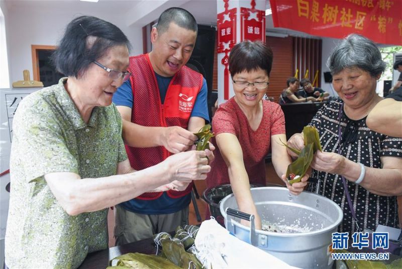6月24日，志愿者与社区的老人们一起包粽子。 当日，浙江省慈溪市钱海军志愿服务中心的志愿者们来到慈溪市白果树社区，同社区的老人和居民们开展了“‘棕’情端午，与爱同行”迎端午主题活动。志愿者们与老人们一起包粽子、做香囊，迎接端午节。 新华社记者 徐昱 摄