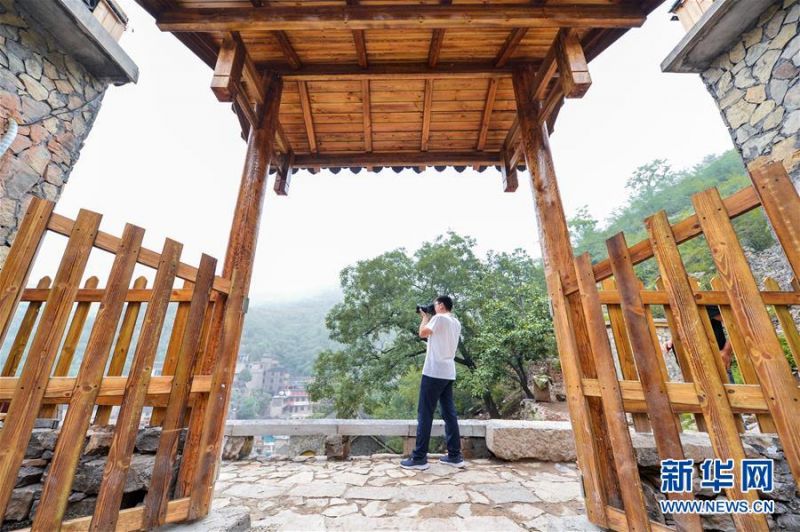 7月10日，游客在涉县更乐镇大洼村一处民宿外拍照。
