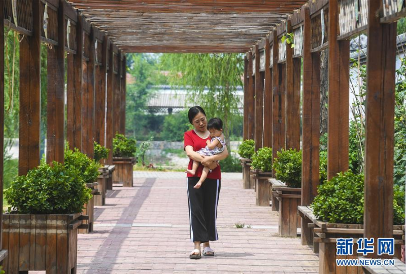 6月27日，河北省故城县郑口镇后响沟村村民在村内休闲长廊里散步。新华社记者 李晓果 摄