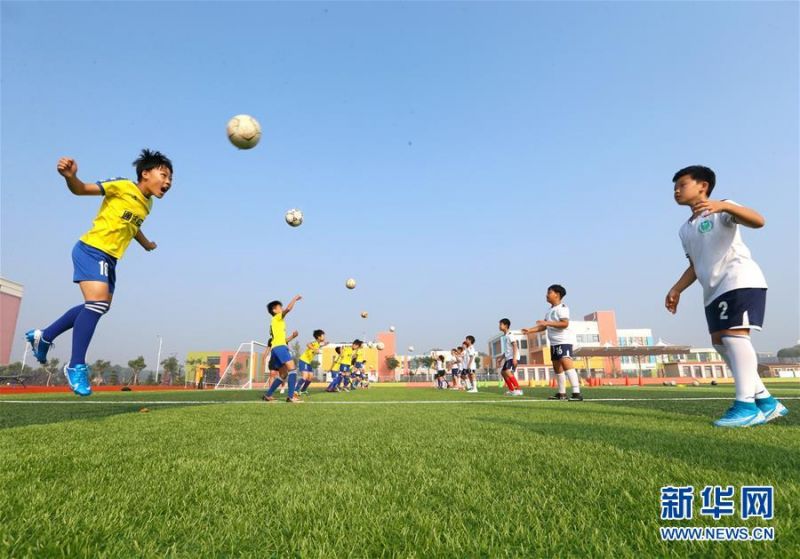 7月16日，青岛通济实验学校的小球员在进行头球训练。 暑假期间，位于山东青岛即墨区的青岛通济实验学校举办暑期足球训练营，小学生在绿茵场上学习足球基础技能，享受快乐暑假。 新华社发（梁孝鹏 摄）