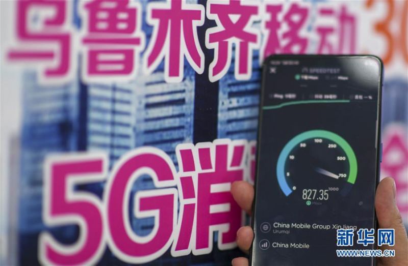 在中国移动位于乌鲁木齐市新市区北京路的一家营业厅，工作人员在展示5G手机的下载速率（7月3日摄）。新华社记者 赵戈 摄