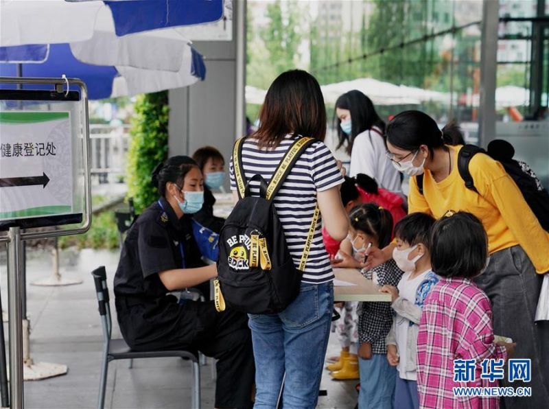 7月15日，在上海自然博物馆入口，工作人员对入馆观众进行健康登记。 进入暑假，不少家长带着孩子到上海自然博物馆参观。该展馆采取实名制分时段购票参观、参观人数分时限流、发布次日参观人数预测等举措，加强防疫常态化管理。 新华社记者 刘颖 摄