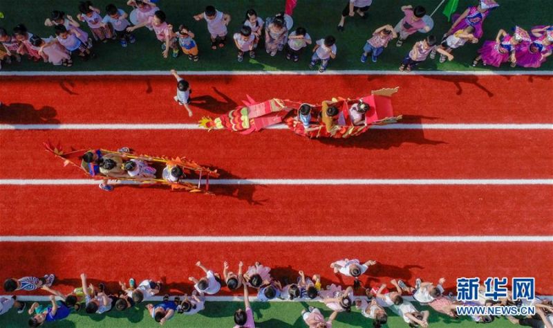 6月24日，四川省遂宁市兴子堂幼稚园的孩子们正在操场上玩“旱地划龙舟”（无人机照片）。 端午佳节将至，各地群众举行了多种多样的活动迎接这一传统节日。 新华社发（刘昌松 摄）