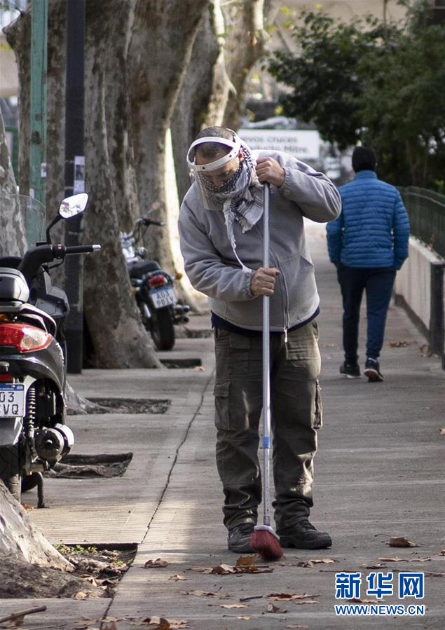7月1日，一名戴面罩的男子在阿根廷布宜诺斯艾利斯街头清扫落叶。 7月1日，阿根廷政府开始重新实行强制性的社交隔离措施。由于近期新冠确诊病例增加明显，阿根廷不得不暂缓许多行业的复工计划。新一阶段隔离措施时间为7月1日至17日，但届时能否“解封”还要取决于隔离效果。 新华社发（马丁·萨巴拉摄）