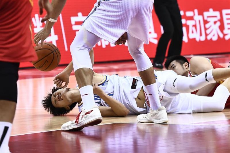 7月10日，苏州肯帝亚球员刘宇轩（左）在比赛中倒地。 当日，在山东青岛举行的2019-2020赛季中国男子篮球职业联赛（CBA）复赛第二阶段（崂山赛区）比赛中，八一南昌队以94比83战胜苏州肯帝亚队。 新华社记者郭绪雷摄