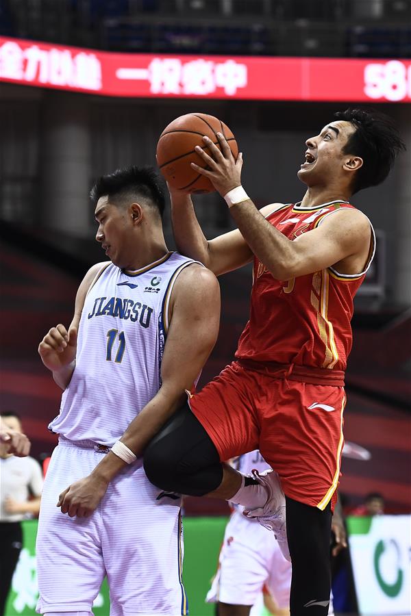 7月10日，八一南昌队球员阿尔斯兰（右）在比赛中上篮。 当日，在山东青岛举行的2019-2020赛季中国男子篮球职业联赛（CBA）复赛第二阶段（崂山赛区）比赛中，八一南昌队以94比83战胜苏州肯帝亚队。 新华社记者郭绪雷摄