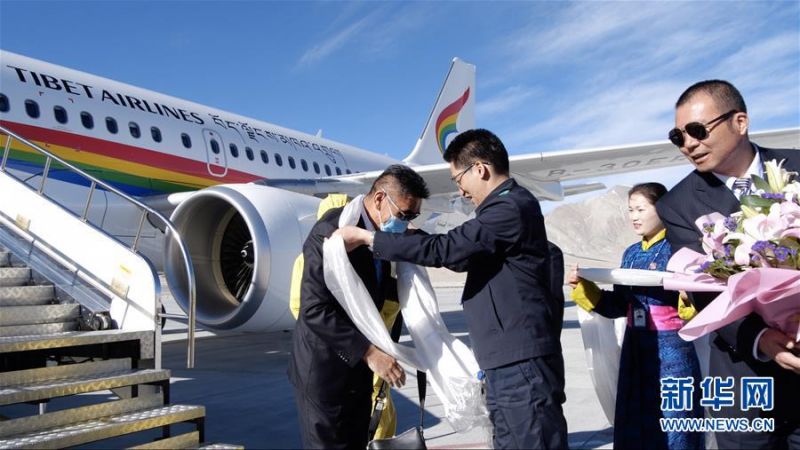 7月1日,西藏航空TV6008客机降落阿里昆莎机场,第一位下飞机的乘客平措旦增接受哈达。 新华社记者 李桢宇 摄