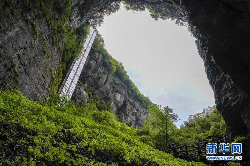7月29日，游客在天生三桥景区内的天龙桥景点游览。 夏日时节，世界自然遗产地重庆武隆天生三桥景区风景如画，气势磅礴的天生石桥和绿意盎然的山林相映成趣，吸引众多游客前来观光。 新华社记者 刘潺 摄