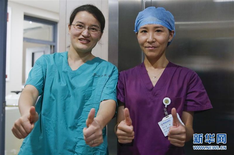 7月3日，中日友好医院检验科新冠核酸检测实验室的闫克芹（左）和张鑫在短暂午休时脱下了防护服。新华社记者 张玉薇 摄