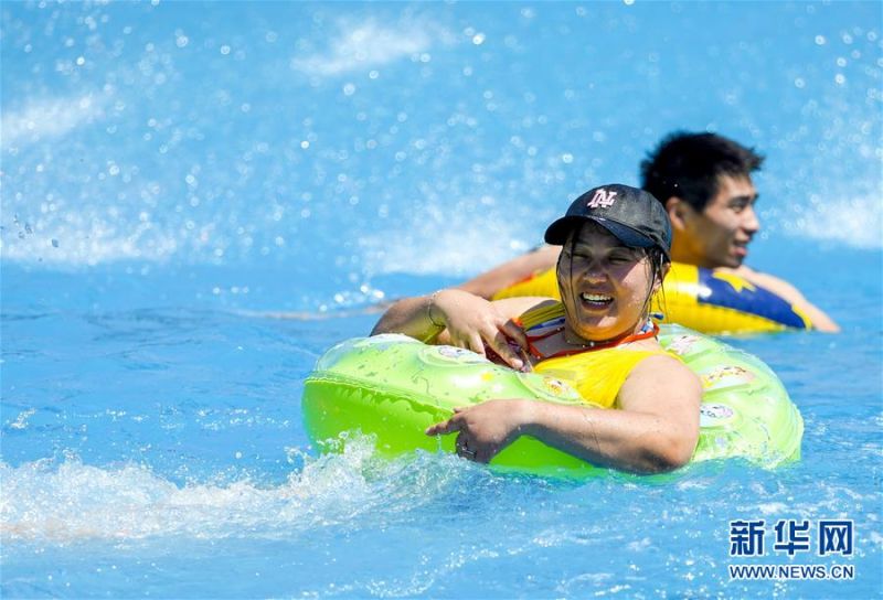 　8月5日，重庆涪陵红酒小镇水上乐园内，市民在水中嬉戏。 当日，重庆市气象台再次发布“高温橙色预警信号”，重庆大部分海拔400米以下地区日最高气温将升至37℃以上，局地可达40℃以上。许多重庆市民涌进当地的水上乐园和泳池，在水中享受夏季的清凉。 新华社记者 刘潺 摄