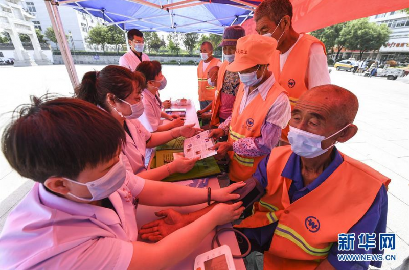 6月25日，景县人民医院医护人员在为环卫工人义诊。 当日是端午节，共青团景县县委、景县人民医院联合该县儒乡青年志愿者协会开展端午送安康关爱环卫工志愿活动。医务人员和青年志愿者为环卫工人包粽子、义诊、理发，送应急药品、消暑水果等，为他们送去夏日清凉和节日关爱。 新华社记者 李晓果 摄