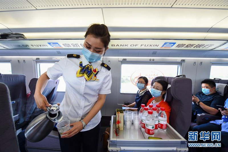 6月30日，G8382次“和谐号”动车组列车的乘务员为旅客服务。新华社记者 彭源 摄
