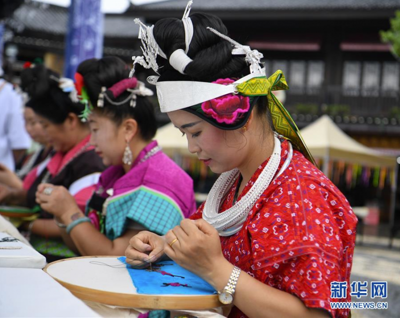 7月3日，在贵州省丹寨县万达小镇景区，苗族妇女在参加刺绣技艺比赛。 当日，贵州省黔东南苗族侗族自治州丹寨县万达小镇景区举办非遗手工技艺比赛，来自各村寨的苗族妇女共聚一堂，参加苗族刺绣、苗族蜡染绘画比赛，以比赛的形式促进非物质文化遗产的传承，吸引了在当地旅游的游客到场欣赏。 新华社发（蔡兴文 摄）