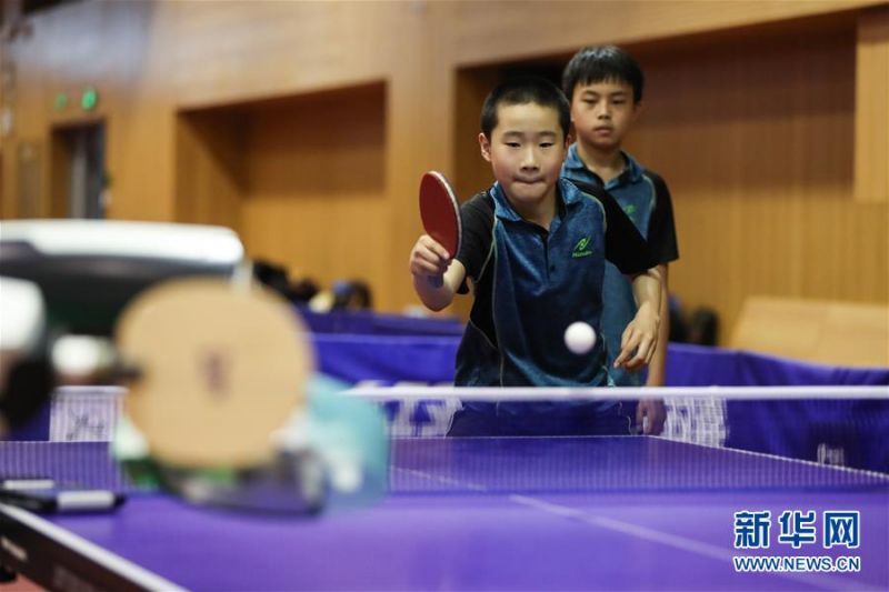7月17日，上海体育学院中国乒乓球学院少年班学员在与乒乓球机器人进行“人机对战”。 当日，上海体育学院中国乒乓球学院参与研发的乒乓球机器人与该学院少年班学员进行了一场“人机对战”展示活动。据介绍，该款乒乓球机器人旨在帮助乒乓球训练变得智能化，未来将有助于乒乓球运动的训练和推广。 新华社记者 丁汀 摄2
