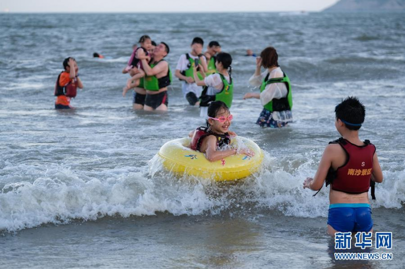 8月2日，夜幕降临，游客在朱家尖南沙景区嬉水。  新华社记者 徐昱 摄