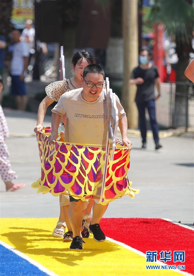 　　6月25日，在重庆市涪陵区美心红酒小镇举办的端午传统民俗体验活动中，市民参加“旱地龙舟”比赛。 当日是端午节，人们外出游玩，乐享假期。 新华社记者 黄伟 摄